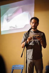 Marco Inguscio recites his prose poems, as Azzurra Cecchini illustrates his words in the background. Photo © Dino Maglie 